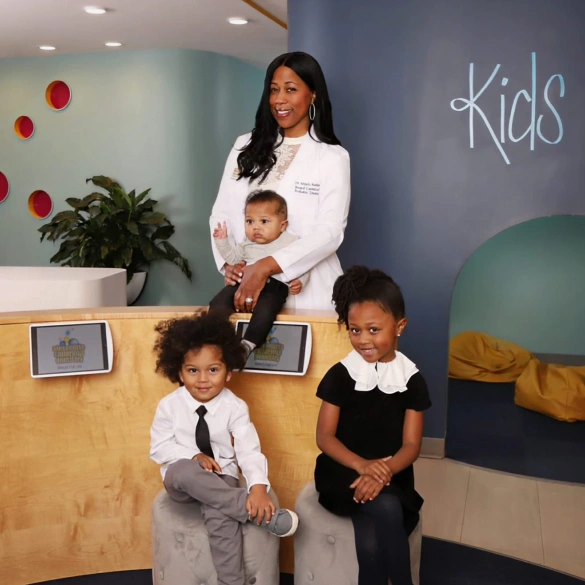 Dr. Angela L. Austin with children in a welcoming dental office reception area